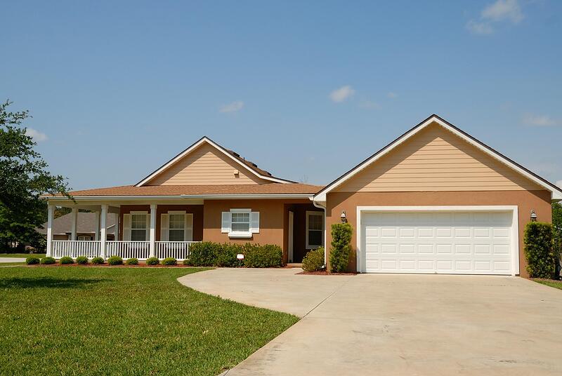 An older Florida home with a narrow driveway and mature trees